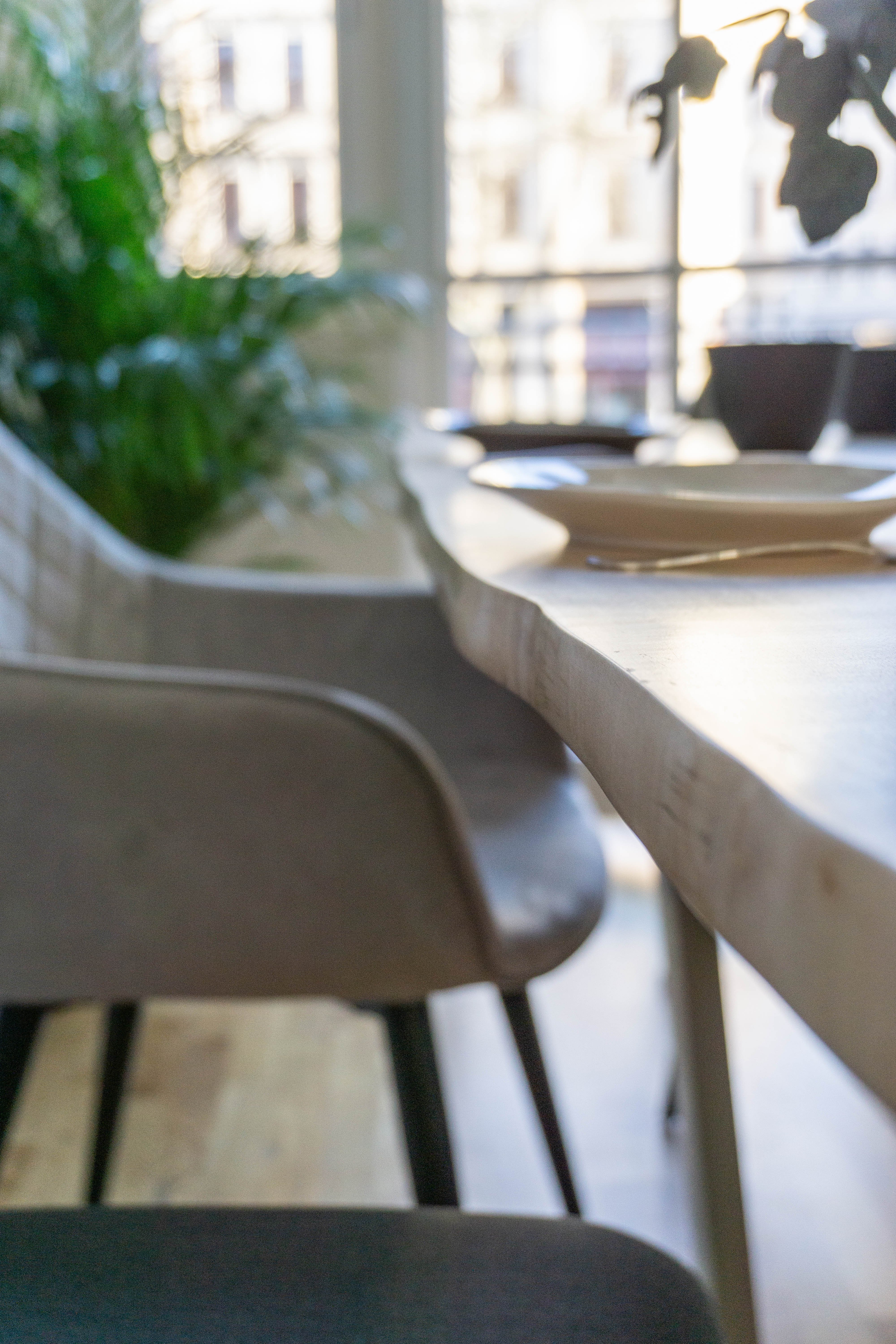 Nahaufnahme der Tischkante aus Ahornholz und des blauen Sicherheitsglases