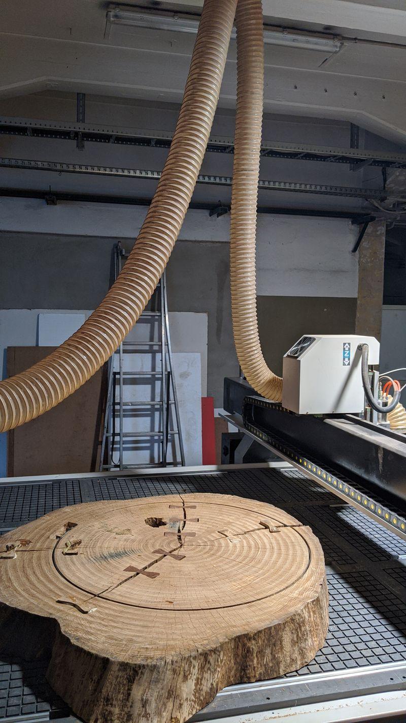 Eichenscheibe wird auf der CNC-Fräse präzise bearbeitet. Exakte Holzbearbeitung für Massivholzprojekte.