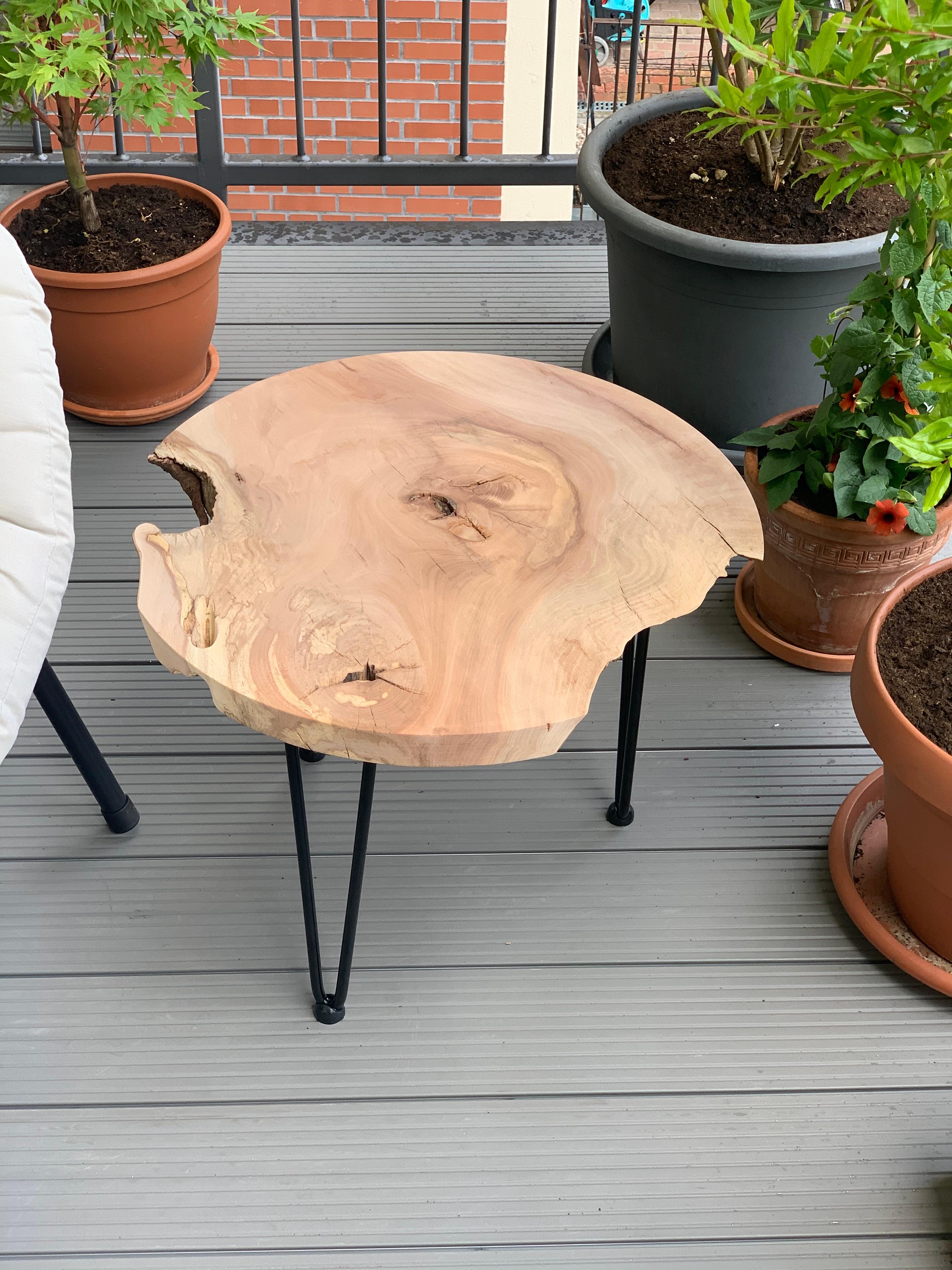 Handgefertigter Massivholztisch auf dem Balkon. Individuell geplant und maßgefertigt für Außenbereiche.