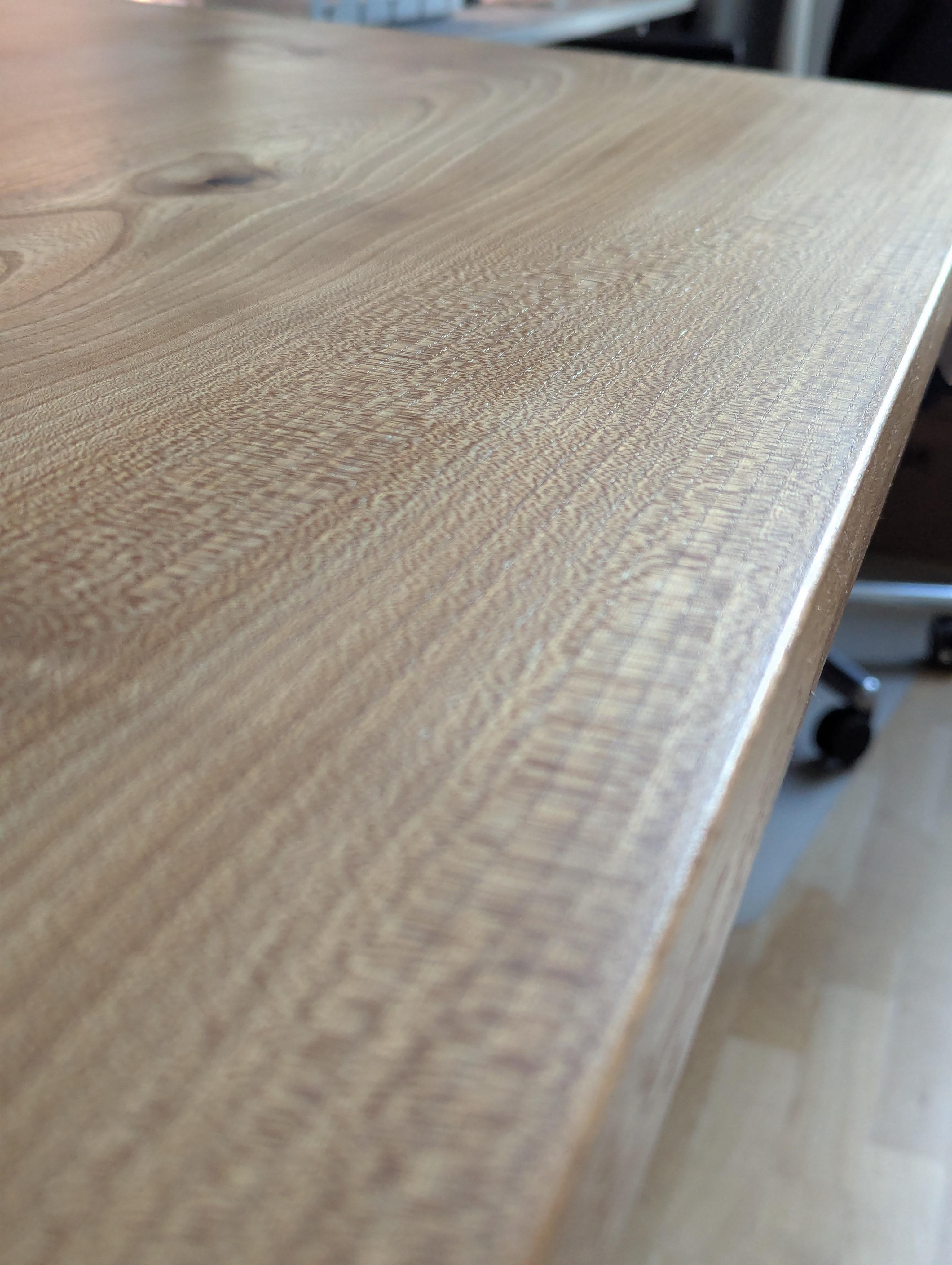 Buchenholz-Schreibtisch mit elektrisch höhenverstellbarem Gestell in seitlicher Perspektive