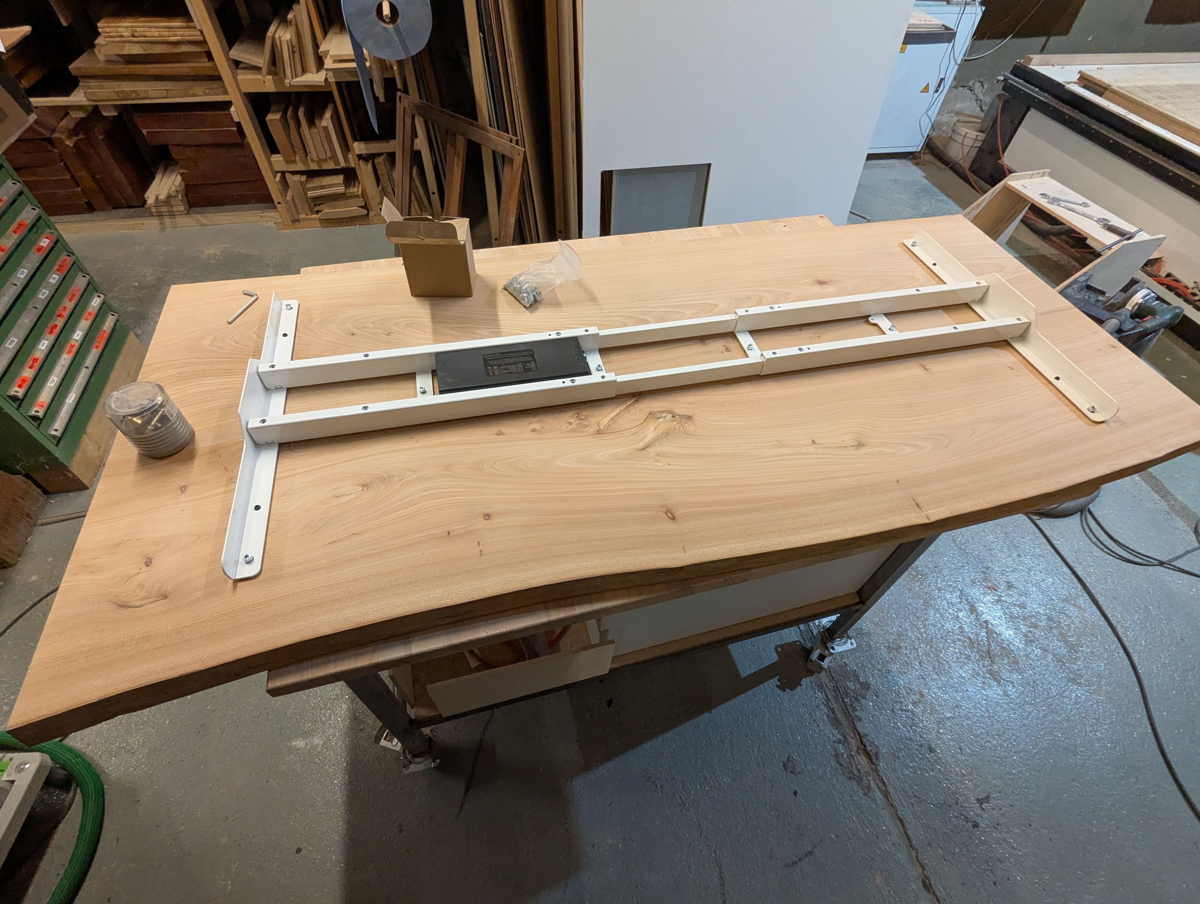 Buchenholz-Schreibtisch mit weißem höhenverstellbarem Tischgestell in schräger Ansicht