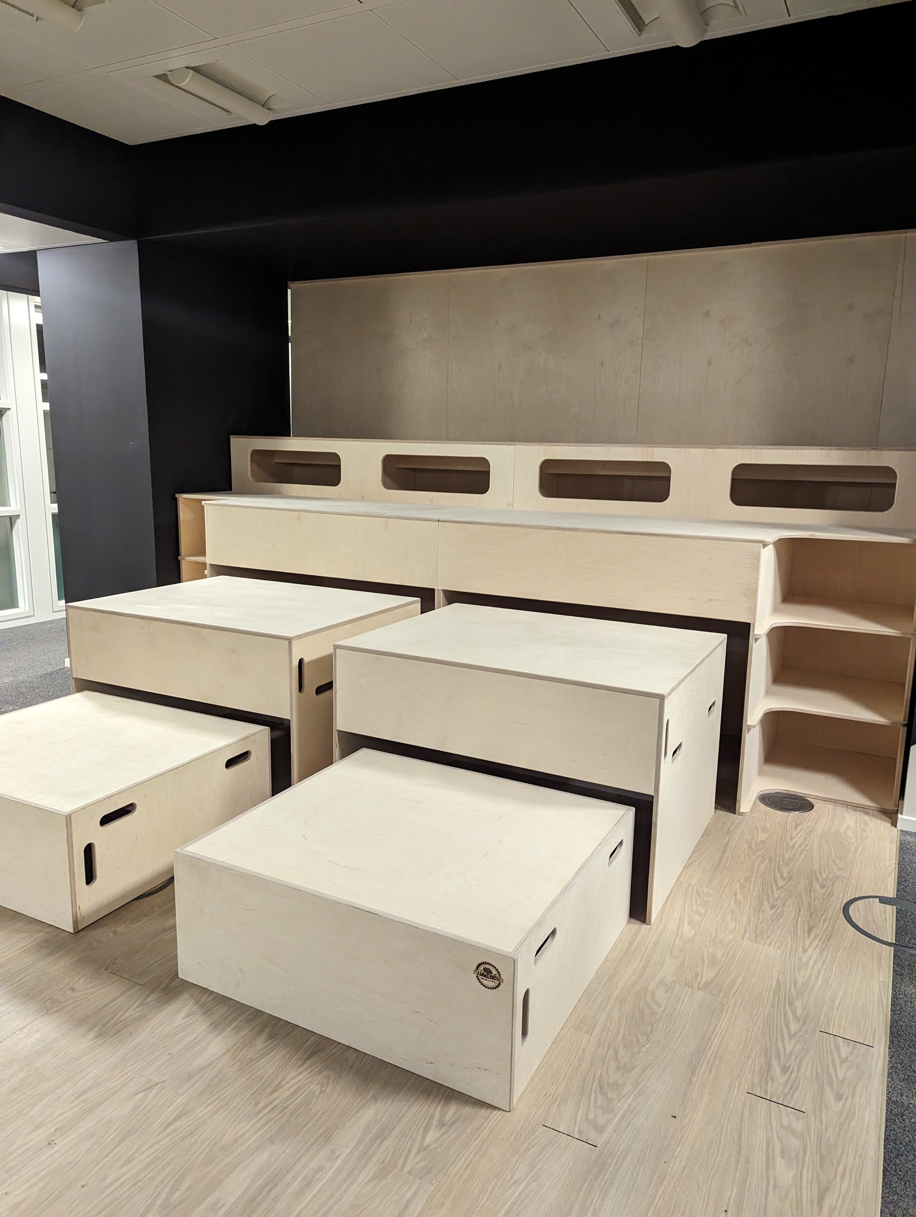 Sitzbühnen-Module aus Birke-Multiplex mit integrierten Staufächern im Basislager Leipzig